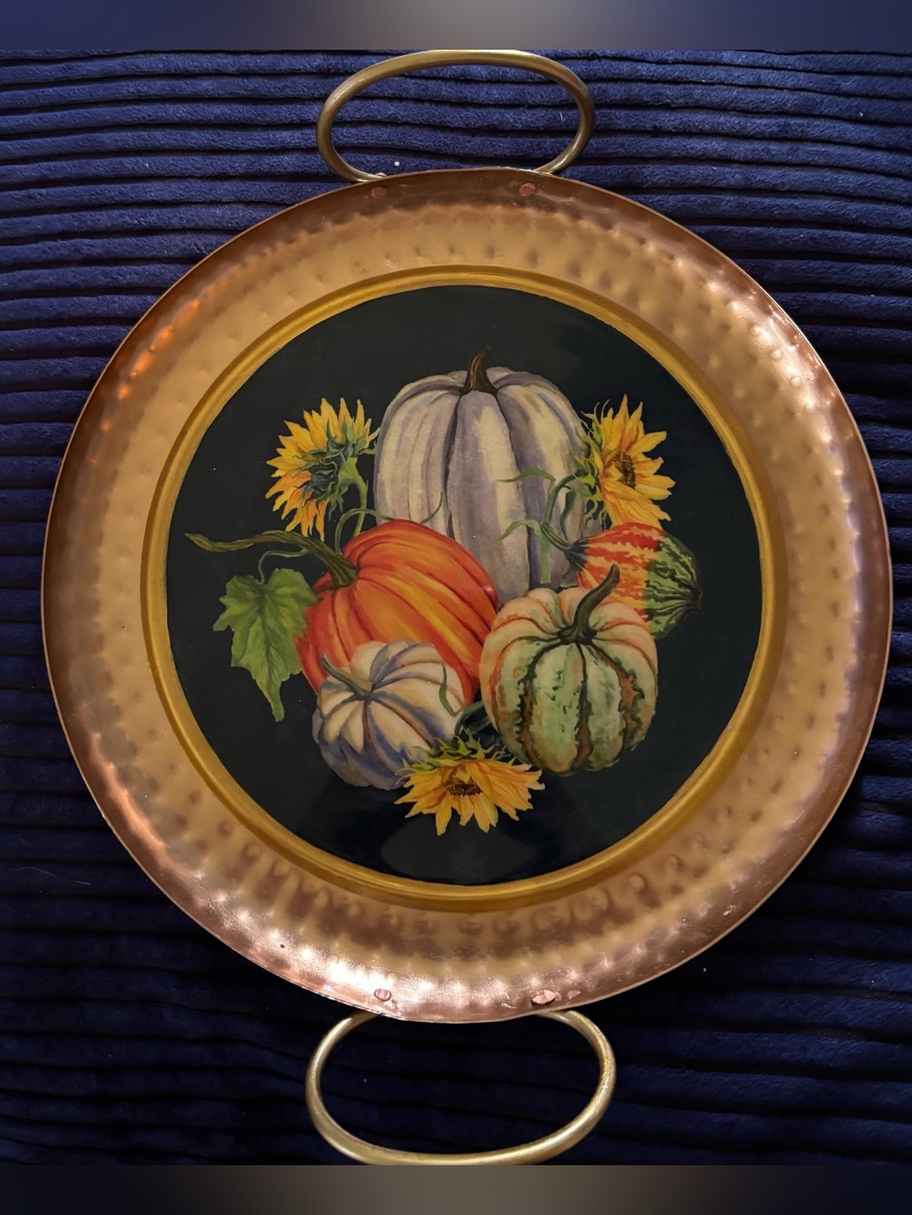 Round serving tray with a hammered copper-finish rim, gold-tone handle